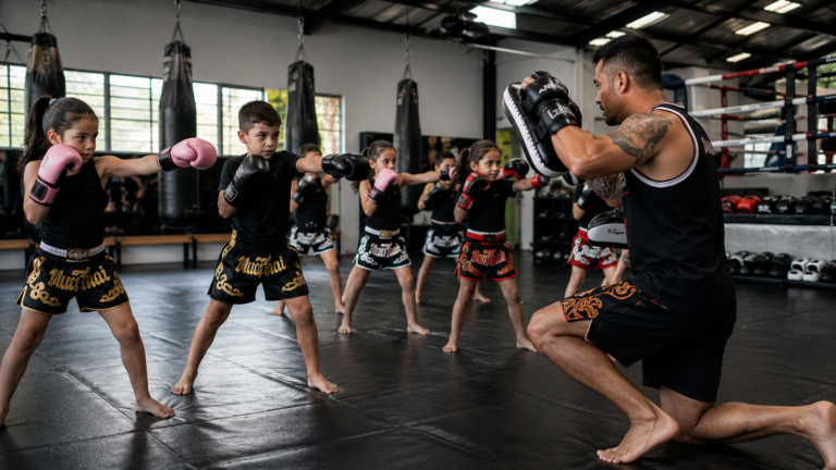 Turma de muay thai infantil em treino no tatame com o instrutor